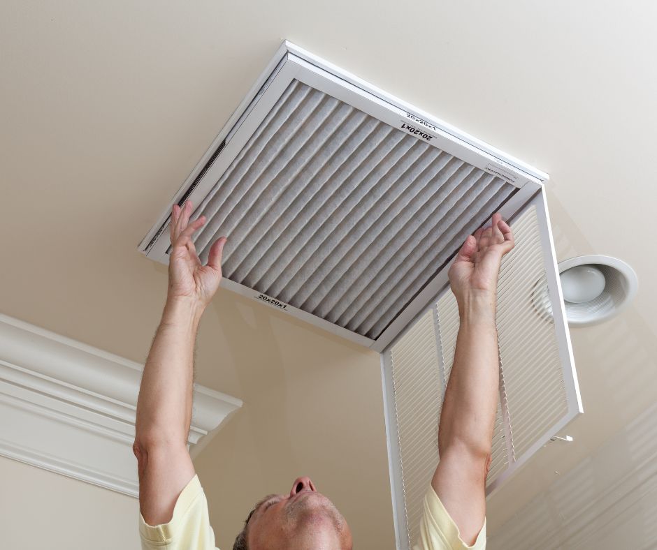 Man changing an air filter in a home's HVAC return